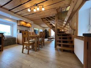 a kitchen and dining room with a spiral staircase in a house at La remise du Murgé in Saulxures-sur-Moselotte