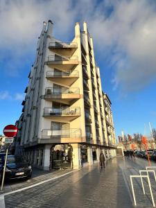 a large building on a street with people walking past it at Cosy Studio Testerep , Newly Renovated in Ostend