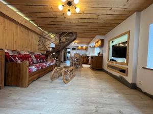 a living room with a couch and a tv at La remise du Murgé in Saulxures-sur-Moselotte