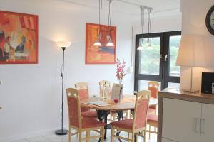 uma cozinha e sala de jantar com mesa e cadeiras em Ferienwohnung Seeblick em Schalkenmehren