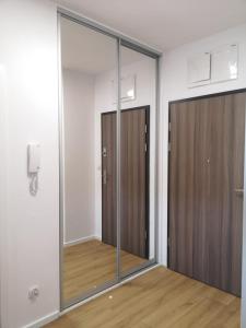 two sliding glass doors in a room with wood floors at Nowoczesny apartament na Promenadach Wroclawskich in Wrocław