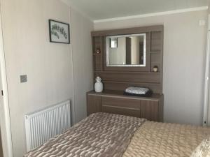 a bedroom with a bed and a mirror at Number 47 @ Lilliardsedge in Jedburgh