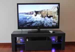 TV de pantalla plana en un centro de entretenimiento negro en Casa Di Ariel, en La Spezia