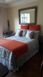 a bedroom with a bed with a red headboard and a mirror at Genie's Nest 3 in Pretoria