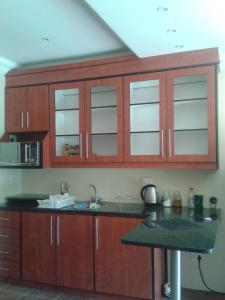 a kitchen with wooden cabinets and a counter top at Genie's Nest 3 in Pretoria
