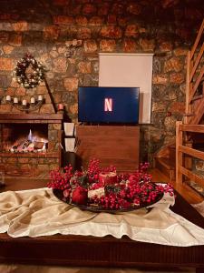 a tray of fruit on a table in front of a tv at Chalet D'elite in Palaios Agios Athanasios