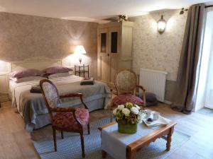 - une chambre avec un lit, deux chaises et une table dans l'établissement Gîte Le Pré du Roc, à Bromont-Lamothe