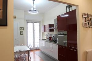 Una cocina con gabinetes blancos y un refrigerador negro. en Casa Di Ariel, en La Spezia