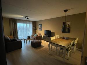 een woonkamer met een houten tafel en een eetkamer bij Appartement Makkum aan het strand in Makkum