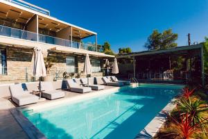 a swimming pool with lounge chairs next to a building at Casa Bloo Adults Only in Elia