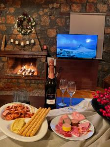 帕雷斯阿吉薩那的住宿－Chalet D'elite，一张桌子,上面放着两盘食物和一瓶葡萄酒
