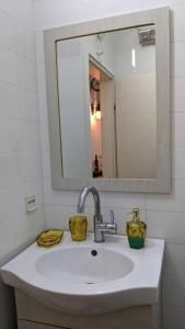ein Badezimmer mit einem Waschbecken, einem Spiegel und einem Waschbecken in der Unterkunft סוויטה הילה במצובה in Maẕẕuva