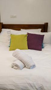białe łóżko z poduszkami i ręcznikiem w obiekcie סוויטה הילה במצובה w mieście Maẕẕuva