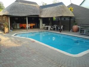 a swimming pool in front of a house at Genie's Nest 4 in Pretoria