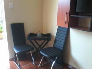 2 Stühle und ein Tisch in einem Zimmer in der Unterkunft Genie's Nest 4 in Pretoria