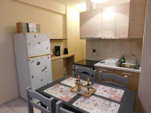 Il comprend une cuisine équipée d'une table, de chaises et d'un réfrigérateur. dans l'établissement HOME SWEET HOME, à Ioannina
