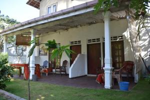 un patio de una casa con sillas y mesa en Aroma Guest House en Mirissa