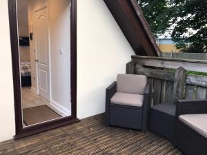 a mirror on a patio with a chair and a mirror at The Firs - Englefied studio in Douglas