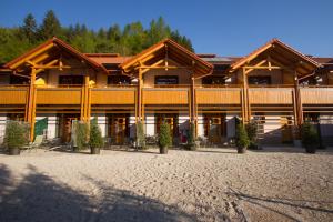 a large wooden building with trees in the background at Natura Amon in Podčetrtek