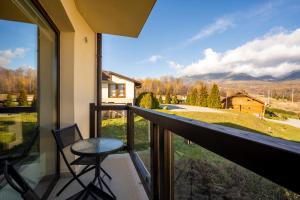 uma varanda com uma mesa e cadeiras e uma vista em Apartment Romana High Tatras-Fantastic views-Washer em Nová Lesná