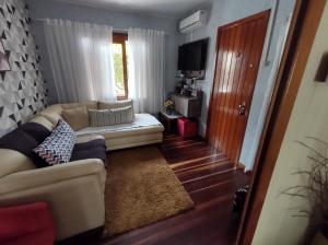 - un salon avec un canapé et une fenêtre dans l'établissement Hospedagem Don Panizzi, à Bento Gonçalves