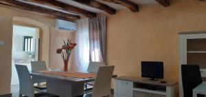 a dining room with a table with chairs and a television at Apartman Miljenka in Pazin