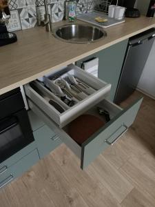 an open drawer in a kitchen with a sink at Cosy T2 in Montbrison