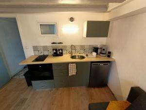 a kitchen with a sink and a counter top at Cosy T2 in Montbrison