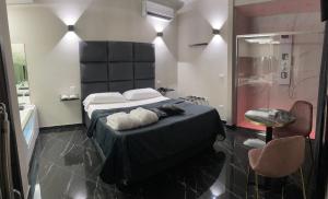 een slaapkamer met een groot bed en een douche bij Hotel Trionfal in Qualiano