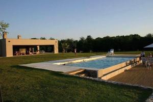 a swimming pool in a field with a building at La Deseada Casa de Campo in La Granja