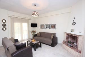 un soggiorno con divano e camino di Luxury Villas Polychrono a Polykhrono