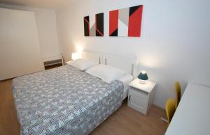 1 dormitorio con 1 cama y una pintura en la pared en Sobe pri Anici en Koper