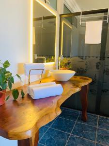 a bathroom with a wooden counter with a sink at Suíte frente mar e pés na areia in Japaratinga