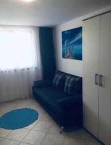 a living room with a blue couch and a window at Delfin Apartments in Crikvenica