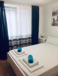 a bedroom with a bed with blue towels on it at Delfin Apartments in Crikvenica