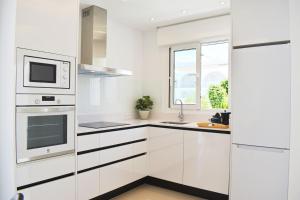 a white kitchen with white cabinets and a window at New Build Apartment on Beautiful Modern Complex in Rojales