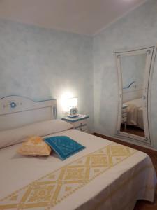 ein Schlafzimmer mit einem Bett mit einem Spiegel und einem Buch in der Unterkunft Le pavoncelle 1 in Calasetta