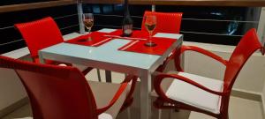 una mesa con sillas rojas y dos copas de vino en GREEN PARK 116E, en Punta del Este