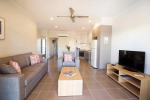 a living room with a couch and a tv at Freshwater East Kimberley Apartments in Kununurra
