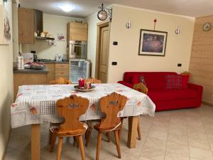 a kitchen with a table and chairs and a red couch at Casa Lina S. Pietro in San Pietro