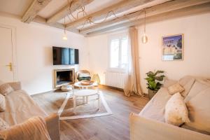 a living room with a couch and a table at La Maison Lamartine Havre de paix dans le centre de Tours in Tours