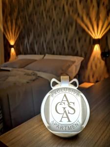 a clock on a table in front of a bed at AGAS Exclusive Apartment in Catanzaro