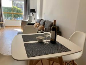 una mesa con una botella de vino y dos copas en Apartamento Plaza, en Villajoyosa