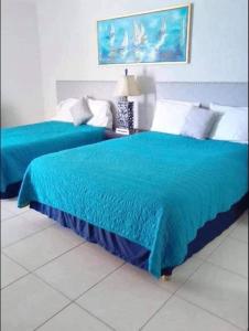 two beds with blue covers in a bedroom at Condominio Posada 314 San Carlos in San Carlos +21 photos