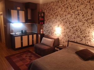 a bedroom with a bed and a chair and a sink at Snowflake Studio in Borovets