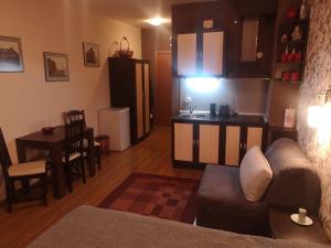 a living room with a couch and a kitchen at Snowflake Studio in Borovets