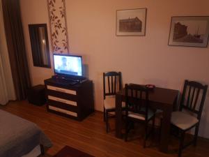 a bedroom with a table and a television on a dresser at Snowflake Studio in Borovets