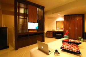 a bedroom with a laptop on a bed with a television at Cool Residence - SHA Plus in Phuket