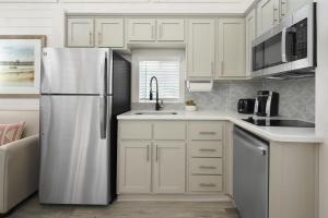 a kitchen with white cabinets and a refrigerator at Sun Outdoors San Diego Bay in Chula Vista