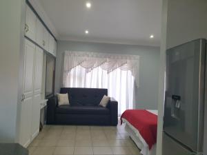 Pretoria的住宿－Genie's Nest Ooie 2，客厅,窗户前设有蓝色沙发